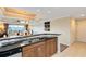 Kitchen featuring granite countertops, wooden cabinetry, and a double sink, with an open view to the living room at 1360 Centre Court Ridge Dr # 201, Reunion, FL 34747
