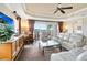 Bright living room with plush carpet, white couches, and a golf course view from the sliding glass doors at 1360 Centre Court Ridge Dr # 201, Reunion, FL 34747