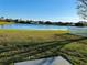Scenic backyard view with lush grass and a tranquil lake at 15090 Waterford Chase Pkwy, Orlando, FL 32828