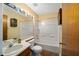 Traditional bathroom with white tiled shower-tub and wood cabinets at 154 Pecan Dr, Ocala, FL 34472