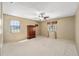 Spacious bedroom with carpet floors, natural light, ceiling fan, and an armoire for ample storage at 154 Pecan Dr, Ocala, FL 34472