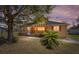 Charming single-Gathering home featuring a covered porch, mature tree, and well-maintained landscaping during twilight at 154 Pecan Dr, Ocala, FL 34472