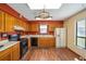 Kitchen with wood cabinets, black appliances, double oven, laminate countertop, and wood laminate flooring at 154 Pecan Dr, Ocala, FL 34472