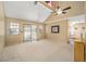 Bright living room with carpet, vaulted ceiling, fan, and sliding glass doors leading to an enclosed patio at 154 Pecan Dr, Ocala, FL 34472