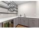 Wet bar features sleek cabinets, wine refrigerator, and unique metal wine rack at 15523 Trotting Horse Ln, Tavares, FL 32778