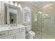 Beautiful bathroom featuring a glass door shower, quartz countertop vanity, and a contemporary framed mirror at 15523 Trotting Horse Ln, Tavares, FL 32778