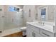 Bathroom features a white vanity with drawers, shower behind glass, and large, frameless mirror at 15523 Trotting Horse Ln, Tavares, FL 32778