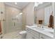 Elegant bathroom features large, glass-enclosed shower, toilet, and white vanity with quartz countertop and decorative mirror at 15523 Trotting Horse Ln, Tavares, FL 32778