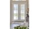Elegant foyer featuring double doors, hardwood floors, and a stylish console table with decorative lamp at 15523 Trotting Horse Ln, Tavares, FL 32778