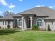 Elegant front entrance showcasing arched windows, stucco facade, and a meticulously landscaped lawn at 15523 Trotting Horse Ln, Tavares, FL 32778
