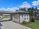 A well manicured lawn and landscaping in front of a three car garage at 15523 Trotting Horse Ln, Tavares, FL 32778