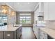 Elegant kitchen with island, white cabinets, stainless appliances, and a view of the backyard and water at 15523 Trotting Horse Ln, Tavares, FL 32778