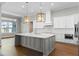 Modern kitchen with white cabinets, gray island, and stainless steel appliances at 15523 Trotting Horse Ln, Tavares, FL 32778