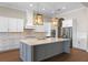 Modern kitchen featuring a large island, stainless steel appliances, and custom lighting at 15523 Trotting Horse Ln, Tavares, FL 32778