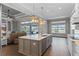 Open-concept kitchen features a large island, stainless steel appliances, hardwood floors, and access to the lanai at 15523 Trotting Horse Ln, Tavares, FL 32778