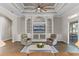 Spacious living room with ceiling fan, hardwood floors, and entertainment center at 15523 Trotting Horse Ln, Tavares, FL 32778