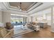 Bright living room features a tray ceiling, modern fan, open floor plan and sliding doors to the outdoor living space at 15523 Trotting Horse Ln, Tavares, FL 32778