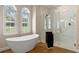 Bright, spacious main bathroom featuring a soaking tub and a glass-enclosed shower at 15523 Trotting Horse Ln, Tavares, FL 32778