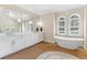 Bright, spacious main bathroom featuring a soaking tub, double vanities, and modern fixtures at 15523 Trotting Horse Ln, Tavares, FL 32778