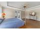 Spacious main bedroom with wood floors, tray ceiling, ceiling fan, and french doors leading to the lanai at 15523 Trotting Horse Ln, Tavares, FL 32778