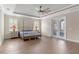 Spacious main bedroom with wood floors, tray ceiling, ceiling fan, and french doors leading to the lanai at 15523 Trotting Horse Ln, Tavares, FL 32778