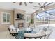 Inviting outdoor living space featuring a stone fireplace with mounted TV and comfortable seating area at 15523 Trotting Horse Ln, Tavares, FL 32778