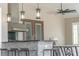 Outdoor kitchen boasts stone counter with pendant lighting and modern stainless steel appliances at 15523 Trotting Horse Ln, Tavares, FL 32778