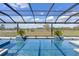 Beautiful pool with a lush green landscape view and blue skies at 15523 Trotting Horse Ln, Tavares, FL 32778