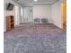 Basement with gray carpet, television, storage shelves, and two lounge chairs at 1905 Snapper Dr, Kissimmee, FL 34759