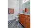 Stylish bathroom with wood floors, wood cabinets, granite countertop, toilet, and mirror at 1905 Snapper Dr, Kissimmee, FL 34759