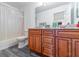 Bright bathroom features wood cabinets and a shower-tub combo with a clean white shower curtain at 1905 Snapper Dr, Kissimmee, FL 34759