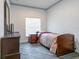 Cozy bedroom with wood floors, neutral paint, bed, nightstand, dresser, and window at 1905 Snapper Dr, Kissimmee, FL 34759