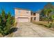 Two-story home featuring an attached garage, covered entryway, and a long concrete driveway at 1905 Snapper Dr, Kissimmee, FL 34759