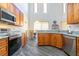 Kitchen featuring wood cabinets, stainless steel appliances, granite countertops, and a vaulted ceiling at 1905 Snapper Dr, Kissimmee, FL 34759
