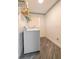 Bright laundry room with wood floors, white washer, and wire shelving at 1905 Snapper Dr, Kissimmee, FL 34759