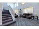 Living room with a staircase, high ceilings, grey wood-look floors, and many windows at 1905 Snapper Dr, Kissimmee, FL 34759