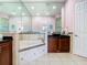 Bathroom featuring a soaking tub with tile surround, a dark wooden vanity, and large mirrors at 20604 Maxim Pkwy, Orlando, FL 32833