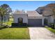 Charming home featuring a two-car garage, lush landscaping, and a well-manicured lawn in a desirable neighborhood at 20604 Maxim Pkwy, Orlando, FL 32833