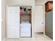 Neat laundry area with a white washer and dryer unit in a closet, shelves, and door at 20604 Maxim Pkwy, Orlando, FL 32833