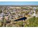 An aerial view presents a tranquil pond surrounded by a mature neighborhood, showcasing lush landscaping and established residences at 2112 White Eagle St, Clermont, FL 34714