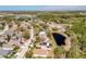 An aerial view showing established neighborhood with lush trees, and a tranquil pond at 2112 White Eagle St, Clermont, FL 34714