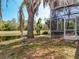Backyard view of the home's screened patio, overlooking a tranquil pond and mature trees at 2112 White Eagle St, Clermont, FL 34714