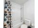 Bright bathroom featuring a shower-tub combination with tiled walls and patterned shower curtain at 2112 White Eagle St, Clermont, FL 34714