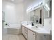 Bright bathroom with double sink vanity, garden tub, and shower at 2112 White Eagle St, Clermont, FL 34714