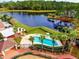 Aerial showcases the luxurious pool area, complete with lush landscaping, a playground, and a serene pond at 2112 White Eagle St, Clermont, FL 34714