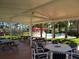 Relaxing covered picnic area complete with dining tables, chairs and view of the pool and mature landscaping at 2112 White Eagle St, Clermont, FL 34714