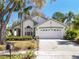 Charming single-story home with a well-manicured lawn, mature trees and attached two car garage at 2112 White Eagle St, Clermont, FL 34714