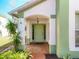 Inviting covered front entrance with a traditional light green front door and well maintained landscaping at 2112 White Eagle St, Clermont, FL 34714