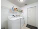 Clean laundry room featuring a washer, dryer, wire shelving for storage, and a door leading outside at 2112 White Eagle St, Clermont, FL 34714