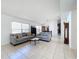 Bright living room with tile floors, grey sofas and views into dining and kitchen areas at 2112 White Eagle St, Clermont, FL 34714